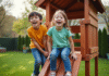 Comment choisir la meilleure aire de jeu en bois pour vos enfants : critères et recommandations Deux enfants rient en jouant dans une aire de jeux en plein air