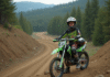 Pourquoi opter pour une Kawasaki 125 cross pour débuter en motocross ? Jeune garçon en équipement motocross avec moto Kawasaki 125