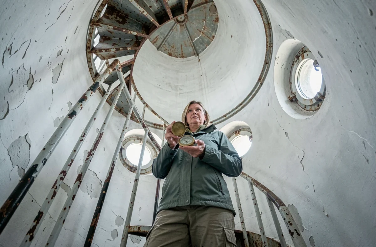 Joueuse explorant l'intérieur d'un phare avec escalier en colimaçon métallique lors de l'escape game Phare de La Coubre à La Tremblade
