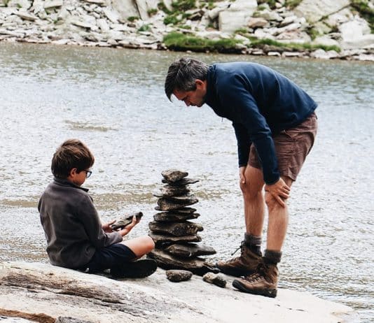 boy and man beside river during daytime