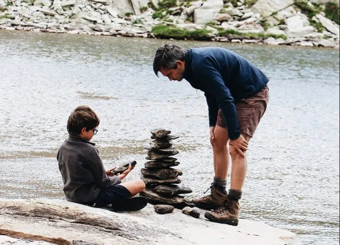 boy and man beside river during daytime